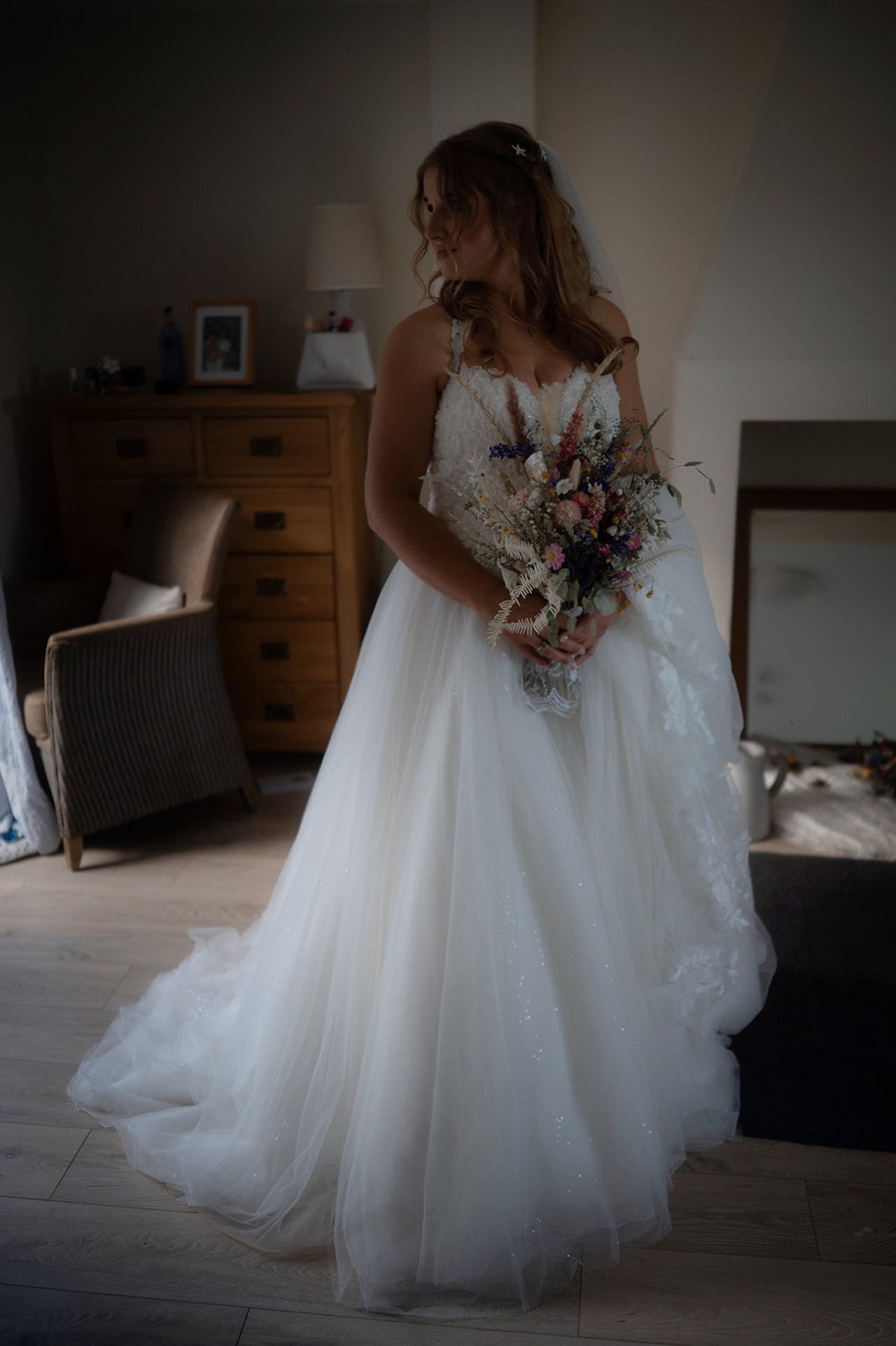 Bride holding bouquet in elegant dress.