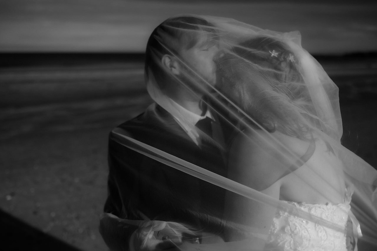 Bride and Groom beach session with veil 